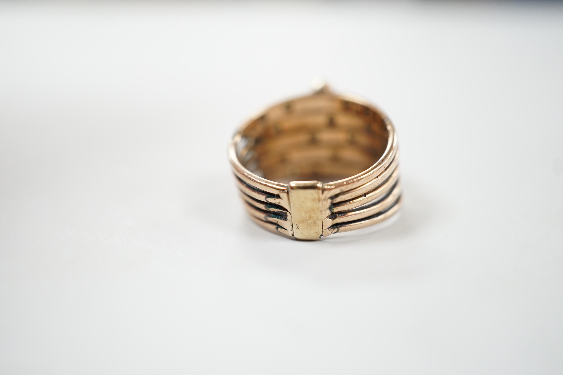 A yellow metal, quintuple band and multi gem set ring (stone missing), size H, gross weight 4.5 grams.